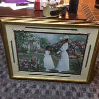 Full view of framed picture featuring a woman and child in white dresses in a garden