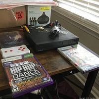 Lot showing Xbox 360 Kinect game, white controller, FUNAI DVD player, and DVD movies on a desk.