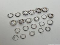 Top view of the full assortment of sterling silver rings arranged in rows on a flat surface.