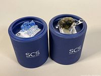 Both figurines seated in original blue SCS cylindrical boxes