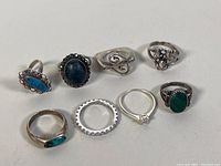 Photo showing all 8 sterling silver rings with various stones and decorative designs on a plain background.
