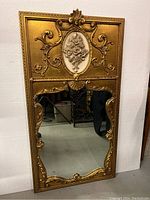 Full front view of rectangular gilt wood mirror showing ornate scrollwork and central medallion