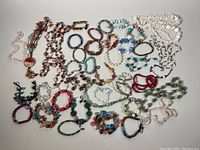 Top down view showing full collection of assorted semi-precious stone beaded jewelry including necklaces and bracelets.