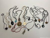 Overview of 14 assorted gemstone pendants on cords and chains