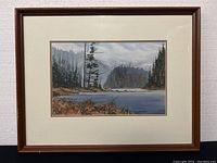 Overall view of framed watercolor painting hung against a white wall
