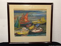 Full view of framed watercolour painting showing boats in various colors on water, cream matting and dark brown frame.