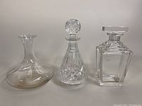 Front view of three cut crystal decanters with varying shapes and sizes