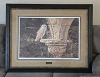 Full front view of the framed print resting on a couch, showing the entire artwork and frame.