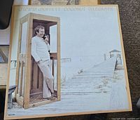 Album cover showing Jimmy Buffett in a telephone booth near the beach on a boardwalk, titled 'Jimmy Buffett Coconut Telegraph.'