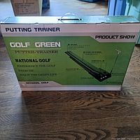 Box front showing Golf-Green Putting Trainer branding and National Golf label with product details.