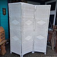 Front view of the white three-panel rattan room divider showing woven diamond pattern details on each panel.