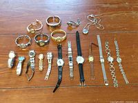 Overview photo showing all 19 watches arranged on wooden surface with various band types and styles.