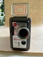 Front view of Kodak Brownie 8mm movie camera showing lens, settings dial, and foldable viewfinder