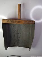 Front view of the antique wooden grain scoop showing metal scoop section and wooden handle.