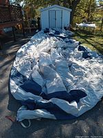 RV cover fully extended on the ground showing size and two-tone color of white with dark blue sections.