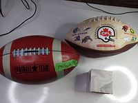 Overview of all three items: red piggy bank, CFL 2003 football, and sealed silver football collectible
