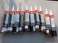 Several tubes of LePage red caulking laid out in a row showing front and side packaging.