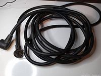 Overall view of coiled black RV extension cord with right-angle plugs