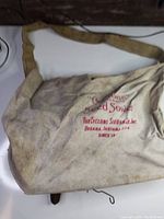 Canvas shoulder bag marked with Cyclone Seed Sower branding from Urbana, Indiana, USA; shows dirt and wear.