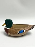 Side view of the ceramic duck figurine showing the hand-painted colors and hollow body