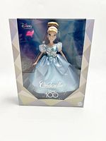 Front view of the unopened Cinderella doll inside box showing the Disney 100 branding and doll visible through clear plastic.