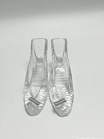 Front view of the pair of crystal glass slippers showing their clear texture and Shannon brand labels.