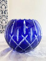 Close-up front view of sapphire blue round crystal rose bowl showing diamond and elongated cut pattern with scalloped edge rim.