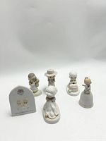 Top view of all six Precious Moments figurines and plaque arranged in a group, showing detailed shapes and colors of each collectible item.