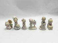Front view showing all six Precious Moments figurines arranged in a row featuring children and themed poses