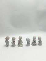 Photo showing all six Precious Moments figurines together on white background.