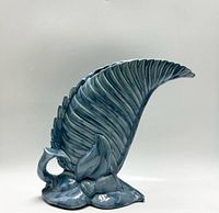 Photo of the blue glazed vintage Royal Haeger Royal Hickman art pottery vase showing the side view with curved leaf design and detailed base.
