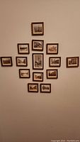 Group of 14 miniature framed prints on a wall, showing a variety of vintage scenic and architectural images.