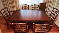 Dining table with six chairs arranged around, showing full set and configuration
