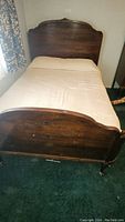 Full view of the 3/4 size wooden bed with mattress, showing the headboard, footboard, and bedding.