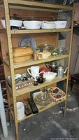Wide view of shelving unit with assorted kitchenware including Corelle and Clay Baker items
