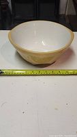 Front view of the ceramic mixing bowl with measuring tape showing approximately 9.5-inch diameter.