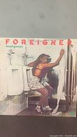 Front cover of the Foreigner Head Games 1979 vinyl record showing original cover art with a woman in a bathroom stall.