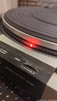 Close-up photo showing the speed control dial and platter edge with a light reflection, indicating a clean and well-maintained part of the turntable.