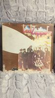 Front side of the Led Zeppelin II album cover showing the band members and logos with signs of wear and discoloration.