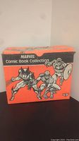 Image of orange Marvel Comic Book Collection box featuring Wolverine, Spider-Man, Captain America on front side.