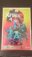 Front cover of Uncanny X-Force #1 comic book showing title and characters, in protective bag and board.