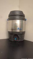 Front view of Bubba Keg water container showing stainless steel and black plastic parts, blue spigot and logo.