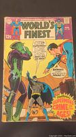 Front cover of the comic showing Superman and Batman with another character, colorful cover with price 12¢ and text details.