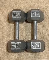 Top view of pair of 25lb hex dumbbells showing raised numbers 25 on each hex end and knurled handles.