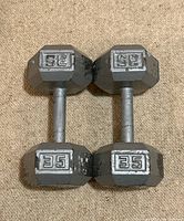 Pair of 35lb metal hex dumbbells on beige carpet with visible wear.