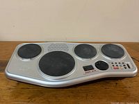 Front-facing photo of Yamaha DD-35 digital percussion machine showing drum pads, speaker grille, LCD, and control buttons.