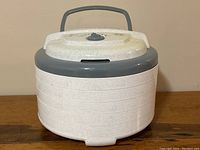 Full view of the Nesco professional food dehydrator showing the unit stacked with multiple trays and handle on top.