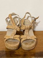 Front view showing woven leather strap design and neutral footbed.