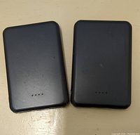Two black portable power banks side by side showing front with LED indicators.