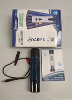 Closed box showing Yabife branding with box, charger cable, grinder device, and user manual laid out